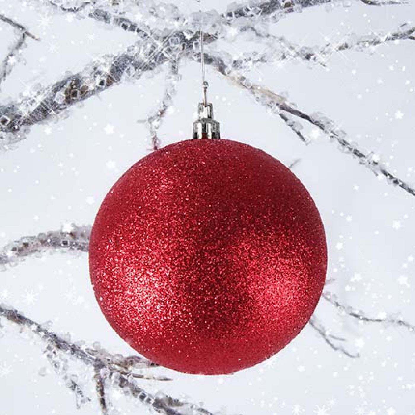 Picture Of red sparkly Christmas ornament hung in ice covered tree